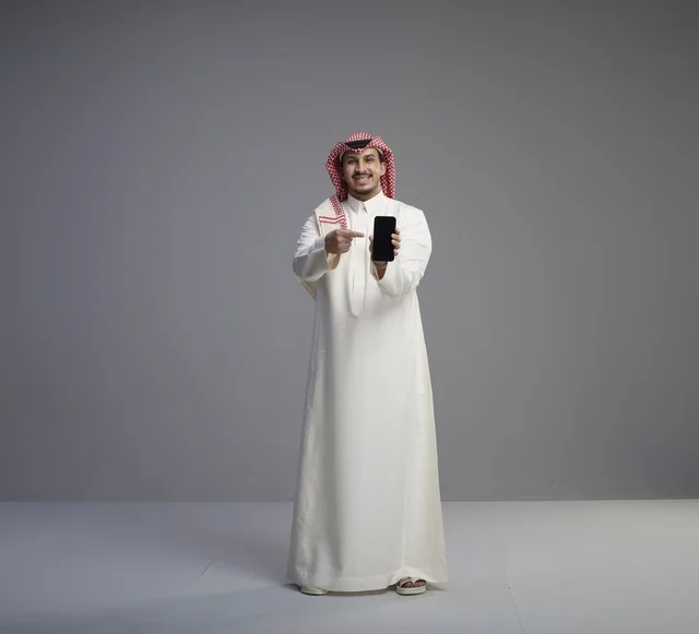Saudi Man Pointing at Smartphone Screen in Studio