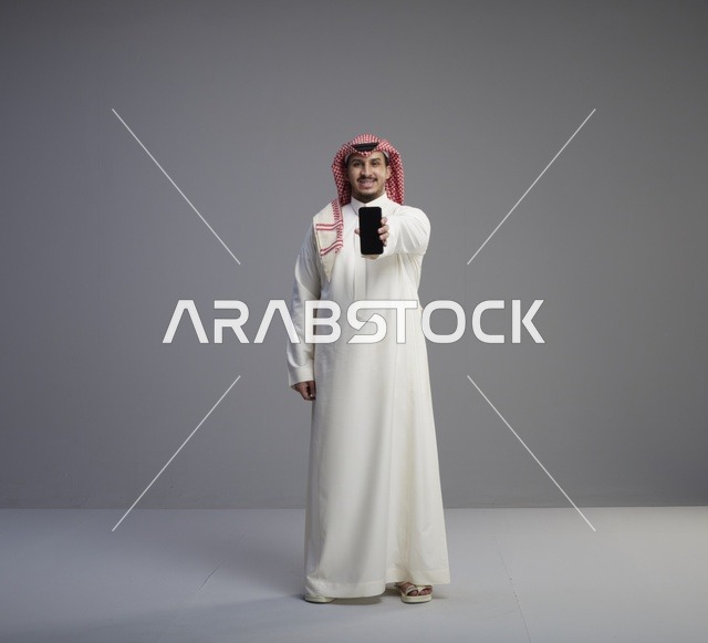 رجل سعودي يحمل هاتف ذكي بشاشة سوداء