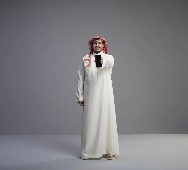 Saudi Man Holding Smartphone with Blank Screen