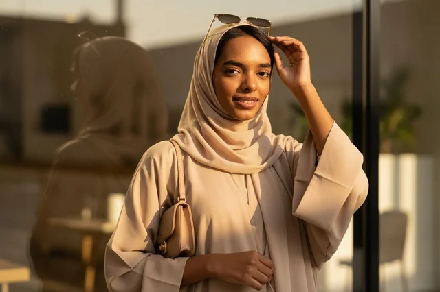 امرأة إماراتية بعباءة بيج خلال وقت الغروب