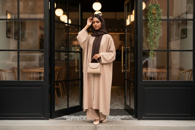 Emirati Woman in Beige Abaya at Modern Cafe Entrance