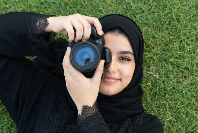 Saudi Woman Photographer with DSLR Camera on Grass