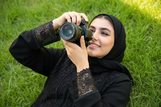 Saudi Woman Photographer in Black Abaya on Green Grass