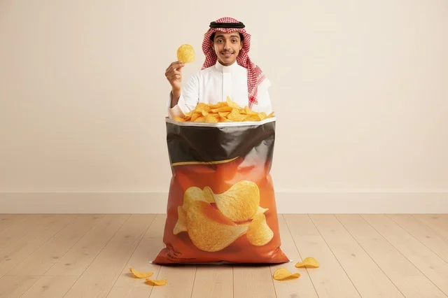 شاب سعودي مع كيس بطاطس مقرمشة عملاق