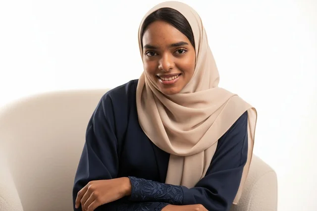 A Saudi woman in a navy abaya and a beige hijab.