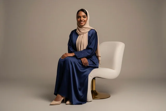 Emirati Woman in Navy Blue Abaya Sitting in Studio
