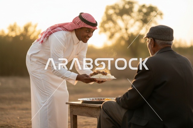 رجل سعودي يقدم طعاماً تقليدياً وقت الغروب