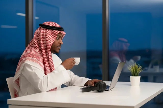 رجل أعمال سعودي يعمل على اللابتوب في مكتب عصري