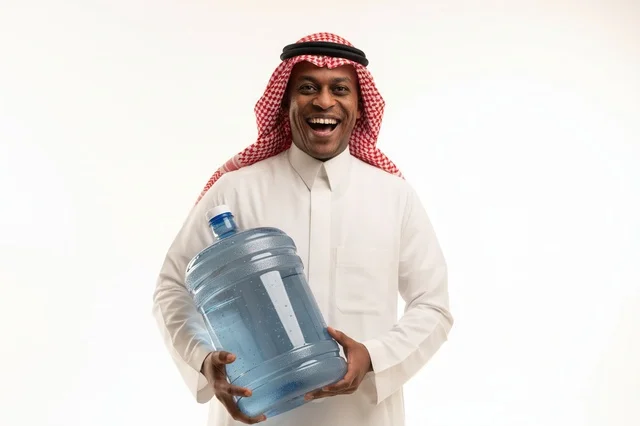 رجل أفريقي بالزي السعودي يحمل قارورة مياه كبيرة