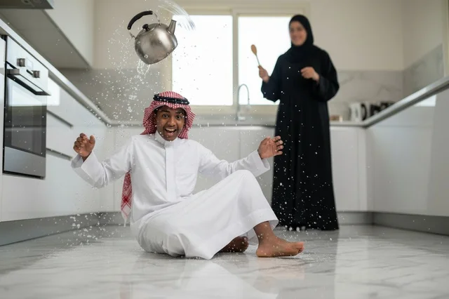 رجل سعودي مصدوم في مطبخ حديث مع إبريق شاي طائر