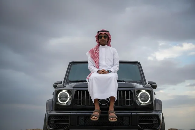 Saudi Man on Black Luxury SUV under Cloudy Sky Saudi Man on Black Luxury SUV under Cloudy Sky