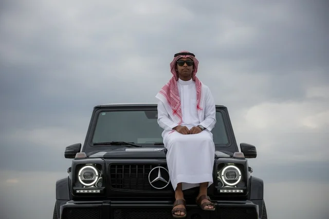 Saudi Man in Traditional Thobe on Black Luxury SUV Saudi Man in Traditional Thobe on Black Luxury SUV