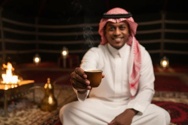 رجل سعودي يقدم القهوة العربية في خيمة صحراوية تراثية