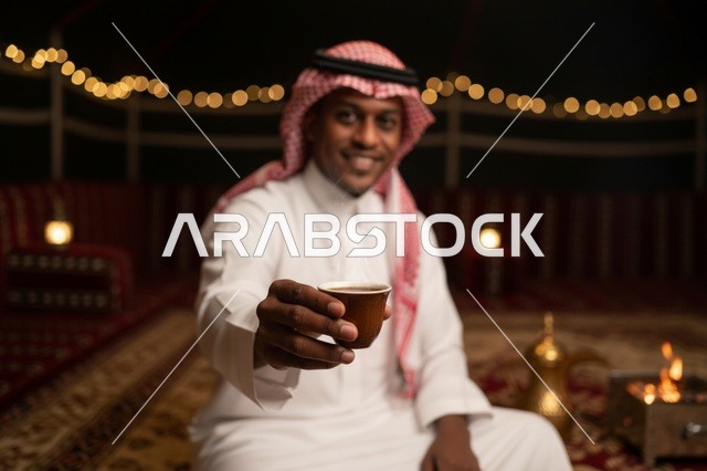 رجل سعودي يقدم القهوة العربية في خيمة تراثية
