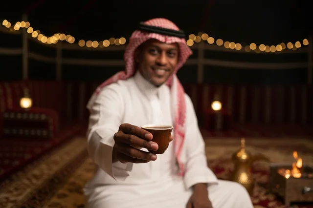 رجل سعودي يقدم القهوة العربية في خيمة تراثية