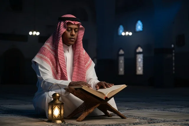 Saudi Man Reading Holy Quran in Mosque with Lantern Saudi Man Reading Holy Quran in Mosque with Lantern