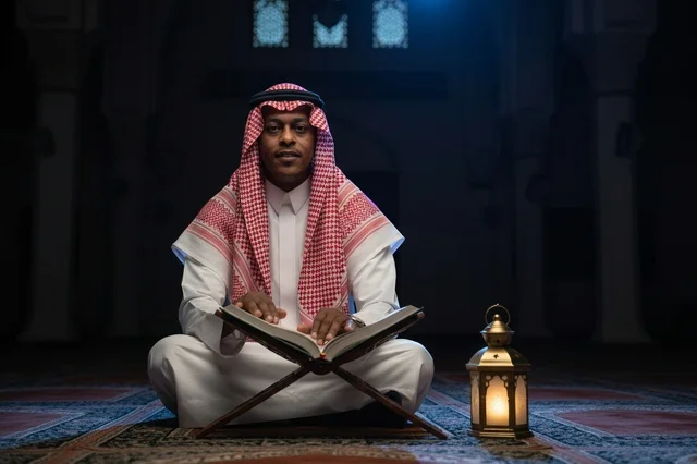 Saudi Man Reading Quran in Mosque with Lantern