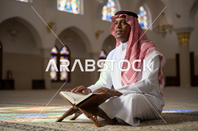 رجل سعودي يقرأ القرآن الكريم داخل قاعة صلاة بالمسجد