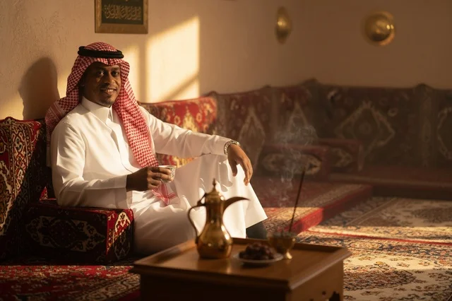رجل سعودي في مجلس تقليدي مع دلة القهوة والتمر