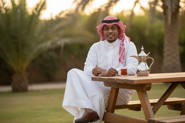 Saudi Man in Traditional Dress with Dallah in Garden