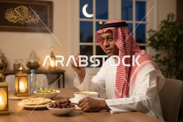 رجل سعودي بالثوب التقليدي يتناول التمر في إفطار رمضان