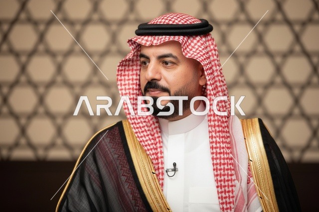 رجل سعودي يرتدي البشت الأسود والشماغ الأحمر التقليدي