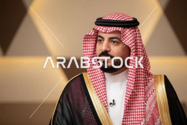 رجل سعودي يرتدي البشت الأسود والشماغ الأحمر التقليدي