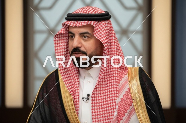 رجل سعودي يرتدي البشت الأسود والشماغ الأحمر التقليدي