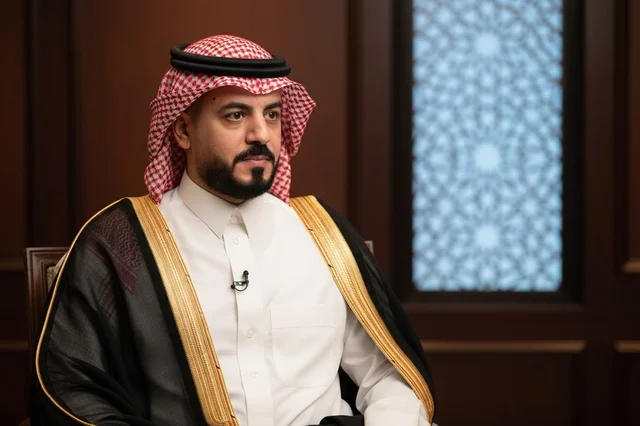 رجل سعودي يرتدي البشت الأسود والشماغ الأحمر التقليدي