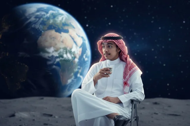 رجل سعودي يشرب القهوة على سطح القمر مع خلفية الأرض