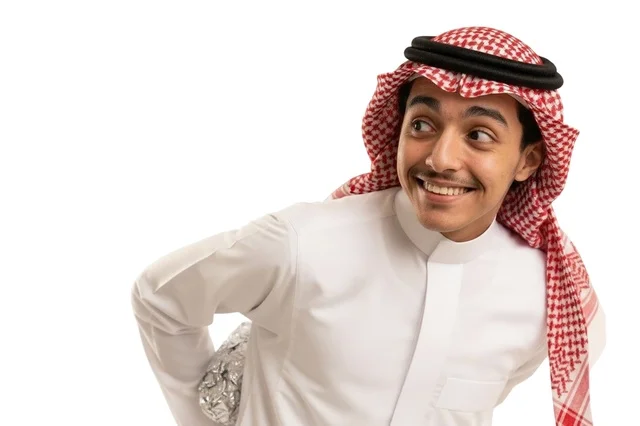 رجل سعودي بالزي التقليدي يخفي هدية خلف ظهره