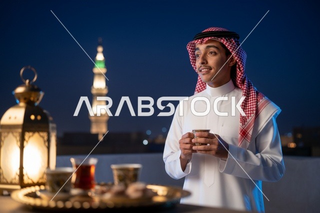 رجل سعودي بالثوب مع فانوس رمضان في الليل