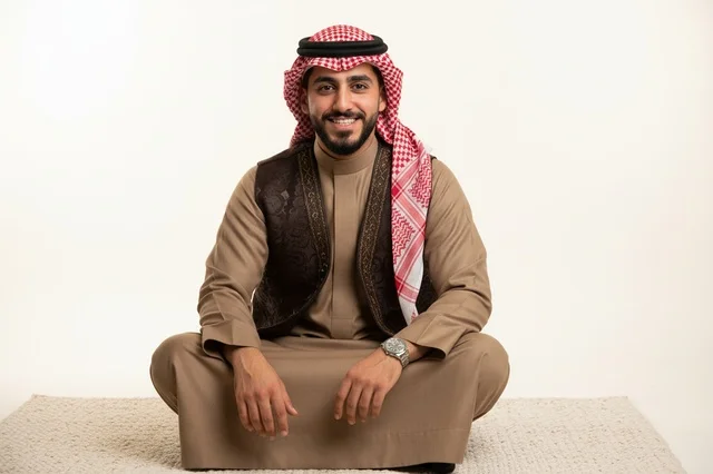 Saudi Arabian Man in Traditional Thobe and Vest Sitting