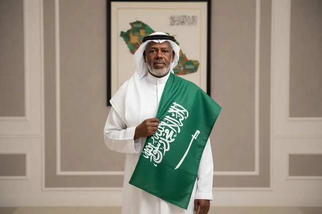 رجل سعودي مسن يحمل علم المملكة العربية السعودية