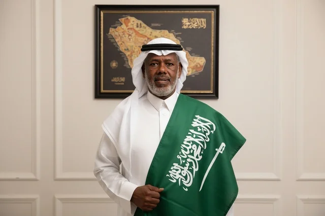 Saudi Man Holding National Flag in Traditional Dress