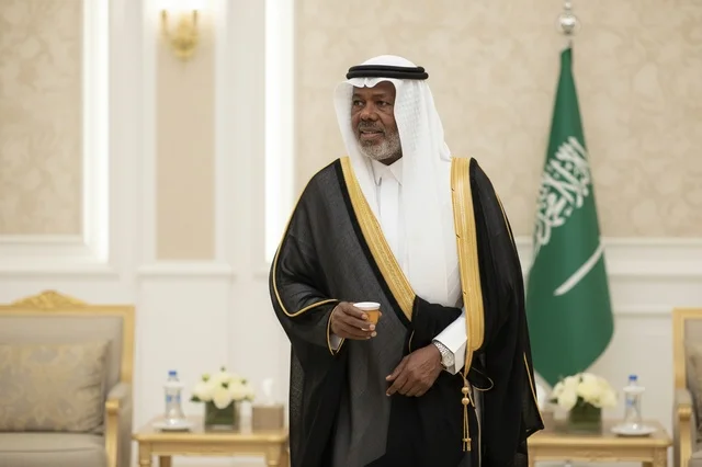 رجل سعودي مسن بالبشت التقليدي يمسك فنجان قهوة