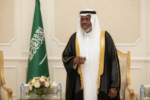 رجل سعودي بالبشت التقليدي يحمل فنجان قهوة