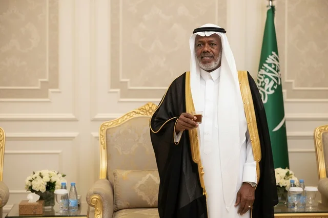 Saudi Man in Traditional Black Bisht Holding Coffee