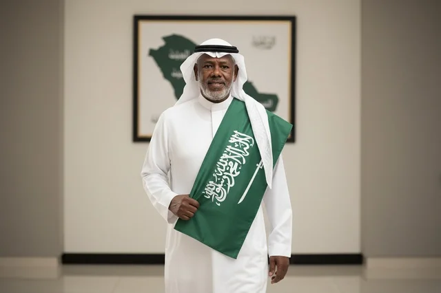 Saudi Man Holding National Flag in Traditional Attire