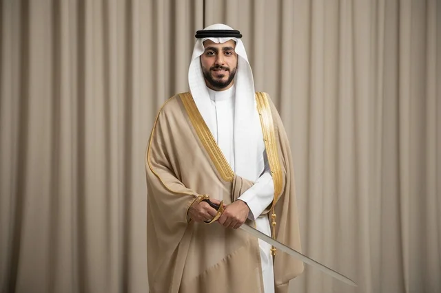رجل سعودي بالزي التقليدي والبشت يحمل سيفاً