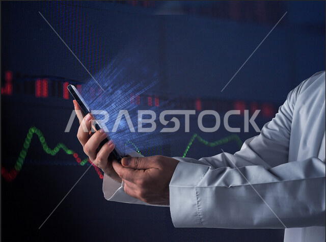 رجل عربي خليجي سعودي يحمل بيده الهاتف المحمول  ، خروج وميض من الخطوط الخاصة باللغة البرمجة  بتقنية الهولوجرام ثلاثية الأبعاد ، تطبيقات و برمجيات  الهواتف المحمولة