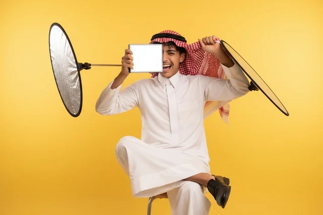 رجل سعودي بالثوب التقليدي مع عاكس إضاءة تصوير