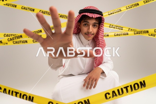 شاب سعودي خلف شريط تحذيري بإشارة توقف
