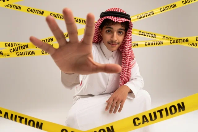 شاب سعودي خلف شريط تحذيري بإشارة توقف