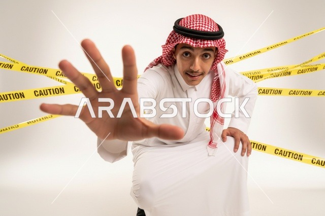 رجل سعودي مع شريط تحذير وإشارة توقف