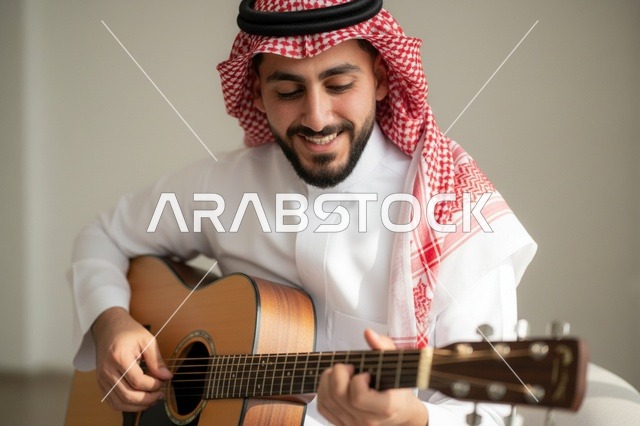 رجل سعودي بالزي التقليدي يعزف على الجيتار