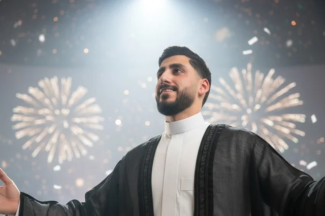 رجل سعودي بالبشت التقليدي يحتفل مع الألعاب النارية رجل سعودي بالبشت التقليدي يحتفل مع الألعاب النارية