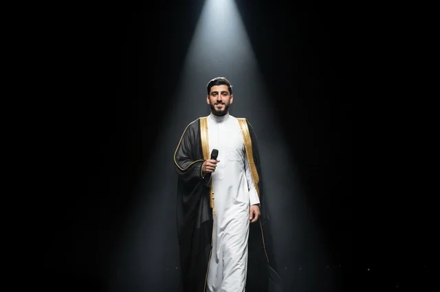 رجل سعودي بالبشت التقليدي تحت ضوء المسرح