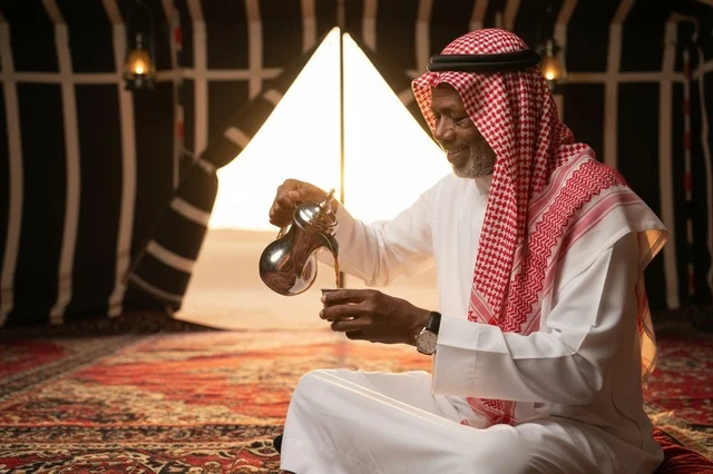 رجل سعودي يصب القهوة العربية في بيت شعر