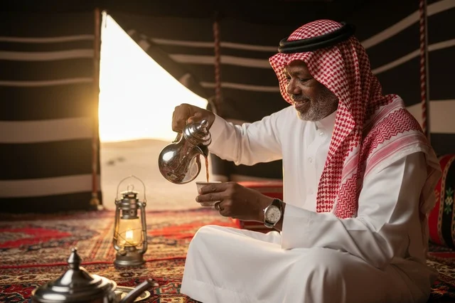 رجل سعودي يصب القهوة العربية في خيمة صحراوية